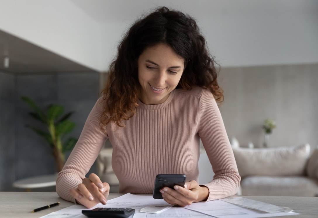 Mujer revisa el móvil para sus cuentas de ahorro